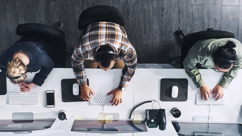 Foto en gran angular de un grupo de agentes de call center trabajando en una oficina