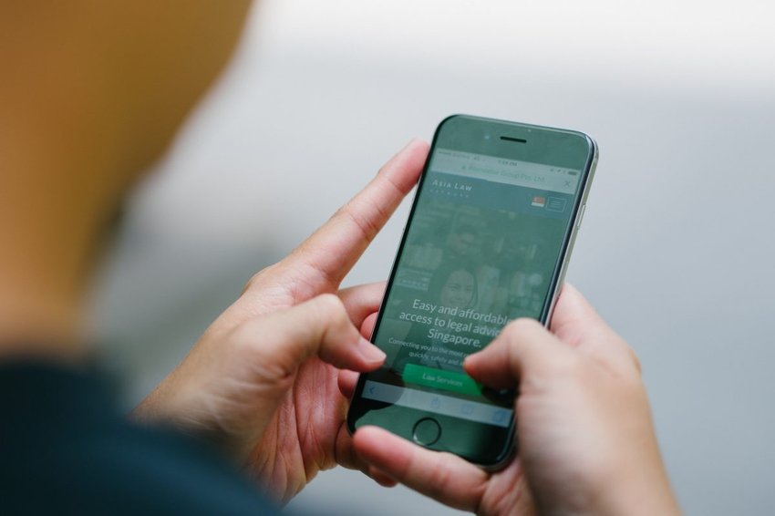 Aplicación telefónica de Asia Law con alguien sosteniendo un teléfono